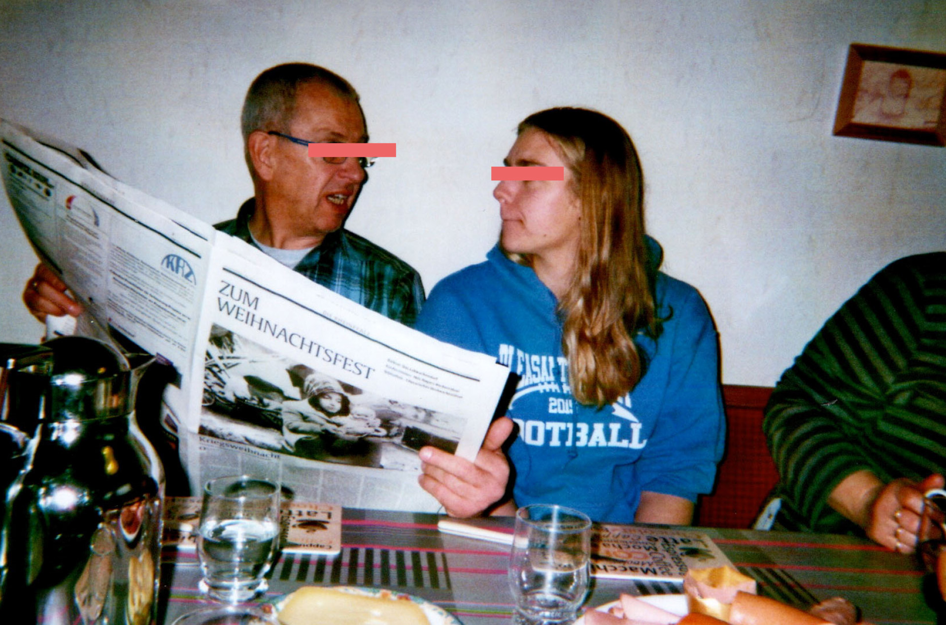 Onkel und Nichte sprechen am Frühstückstisch mit Zeitung in der Hand